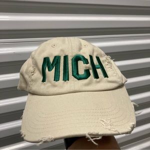 Mich Cream color hat with buckle back and green letters